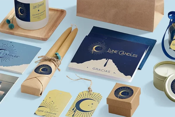 Una exposición de productos de "Lune Candles" que incluye velas, etiquetas de regalo, cajas, una tarjeta, una lata y una bolsa de papel. Decorados con motivos de media luna y estrella, los artículos están ordenados de forma ordenada sobre un fondo azul claro.